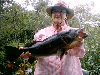Cindy lands a nice peacock bass out of the jungle trees and brush while fishing with Amazon guide Harold!